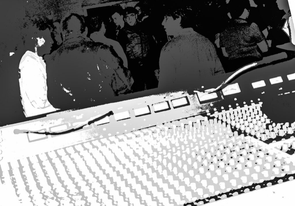 Mixing console in foreground with concert crowd